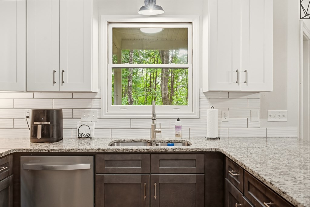 175 Crane Creek Road Young Harris, GA 30582 - Photo 17 of 40 a kitchen with stainless steel appliances granite countertop white cabinets sink and window