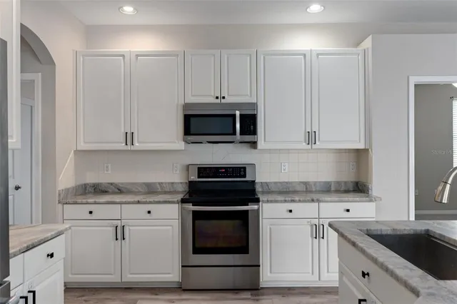 a living room with furniture a ceiling fan and a chandelier
