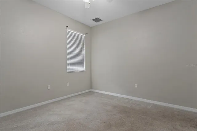 a front view of a house with a yard and potted plants
