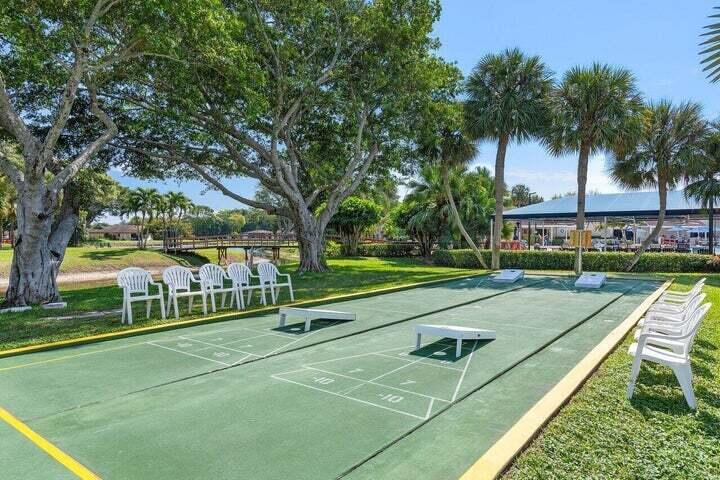 10110 Cedar Point Boulevard, Unit 203 Boynton Beach, FL 33437 - Photo 25 of 37 a view of a tennis ground with large trees