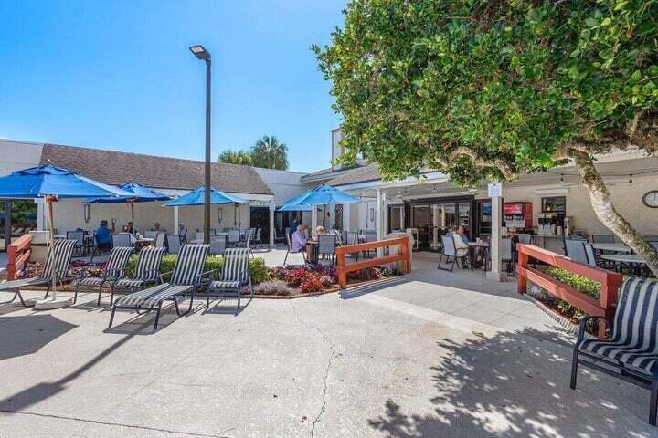 10110 Cedar Point Boulevard, Unit 203 Boynton Beach, FL 33437 - Photo 29 of 37 a view of a patio with a table chairs and a fire pit