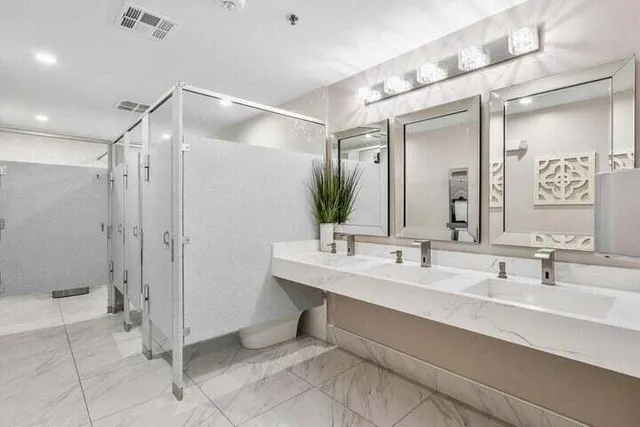 a living room with couches chandelier and kitchen view