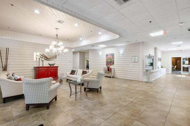 10110 Cedar Point Boulevard, Unit 203 Boynton Beach, FL 33437 - Photo 35 of 37 a living room with couches chandelier and kitchen view