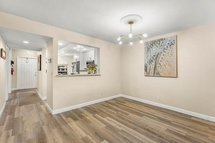 10110 Cedar Point Boulevard, Unit 203 Boynton Beach, FL 33437 - Photo 6 of 37 a view of a hallway with wooden floor and a large window