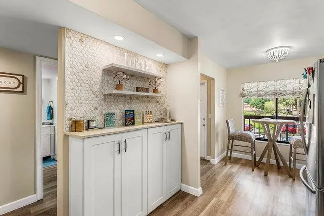 a kitchen with stainless steel appliances white cabinets and wooden floors