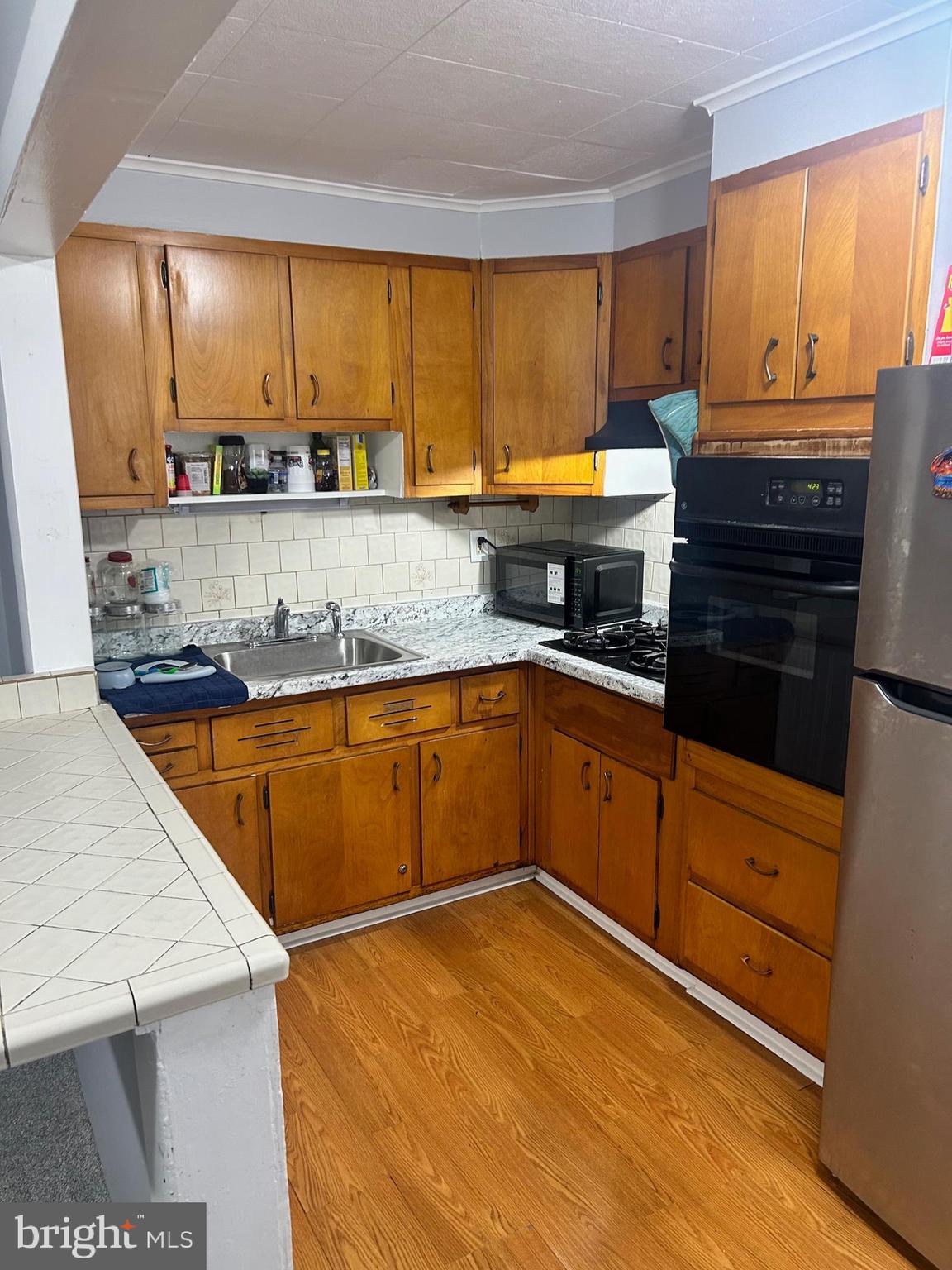 306 Golf Road Darby, PA 19023 - Photo 5 of 14 a kitchen with stainless steel appliances granite countertop wooden cabinets and a stove
