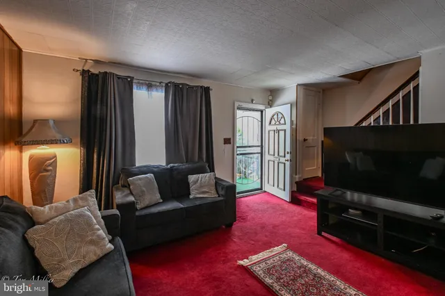 a living room with furniture rug and a flat screen tv