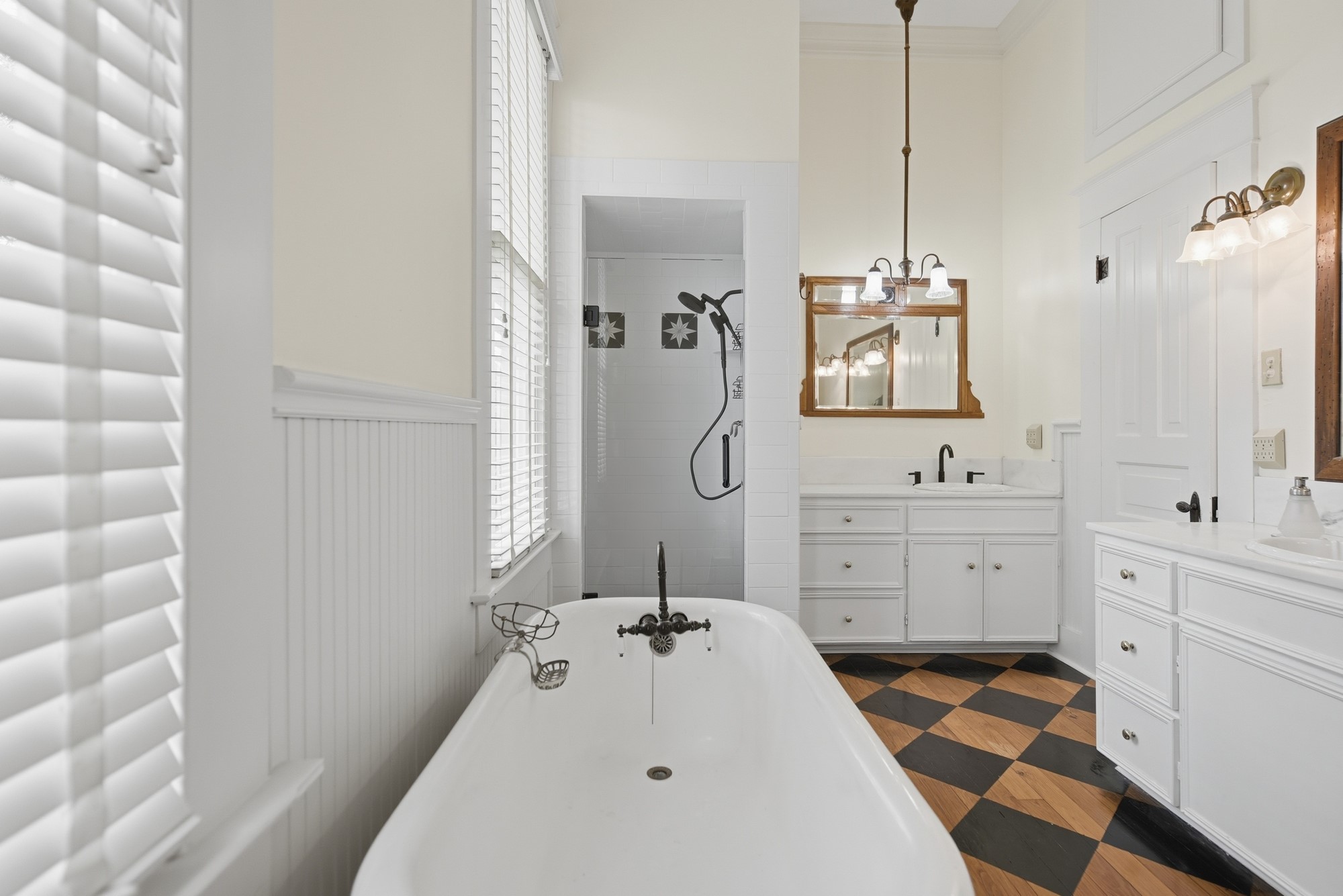 1406 Key Street Brenham, TX 77833 - Photo 20 of 50 Experience luxury in the primary en-suite with stunning antique hardwood floors, elegant double vanities, and a relaxing soaking tub.