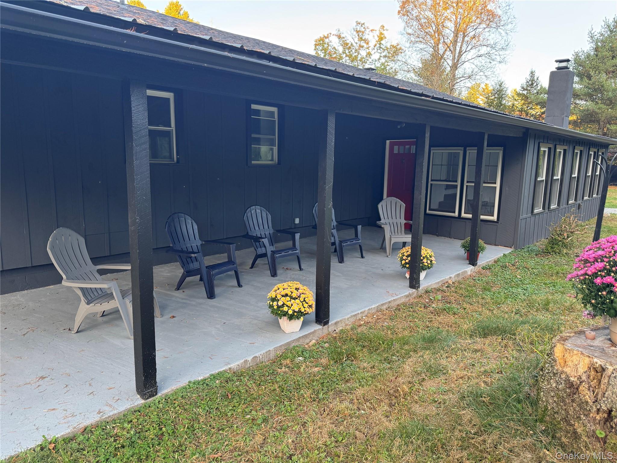 273 Blind Pond Road Narrowsburg, NY 12764 - Photo 2 of 30 Back of house with a chimney, board and batten siding, a patio area, and a lawn
