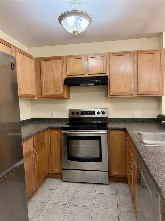 75 Walnut Street, Unit 312 Peabody, MA 01960 - Photo 2 of 16 a kitchen with granite countertop a stove sink and cabinets