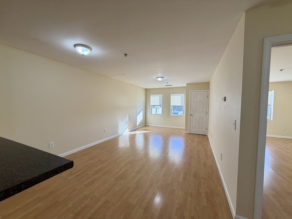75 Walnut Street, Unit 312 Peabody, MA 01960 - Photo 5 of 16 wooden floor in an empty room with a window