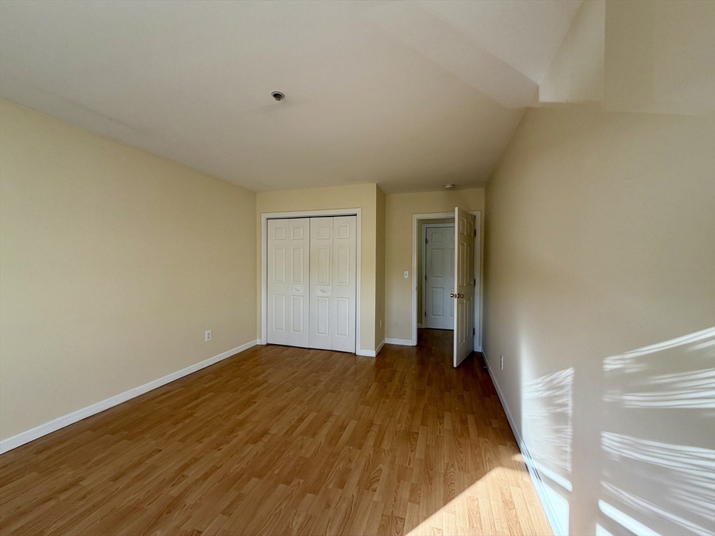 75 Walnut Street, Unit 312 Peabody, MA 01960 - Photo 8 of 16 a view of an empty room and wooden floor