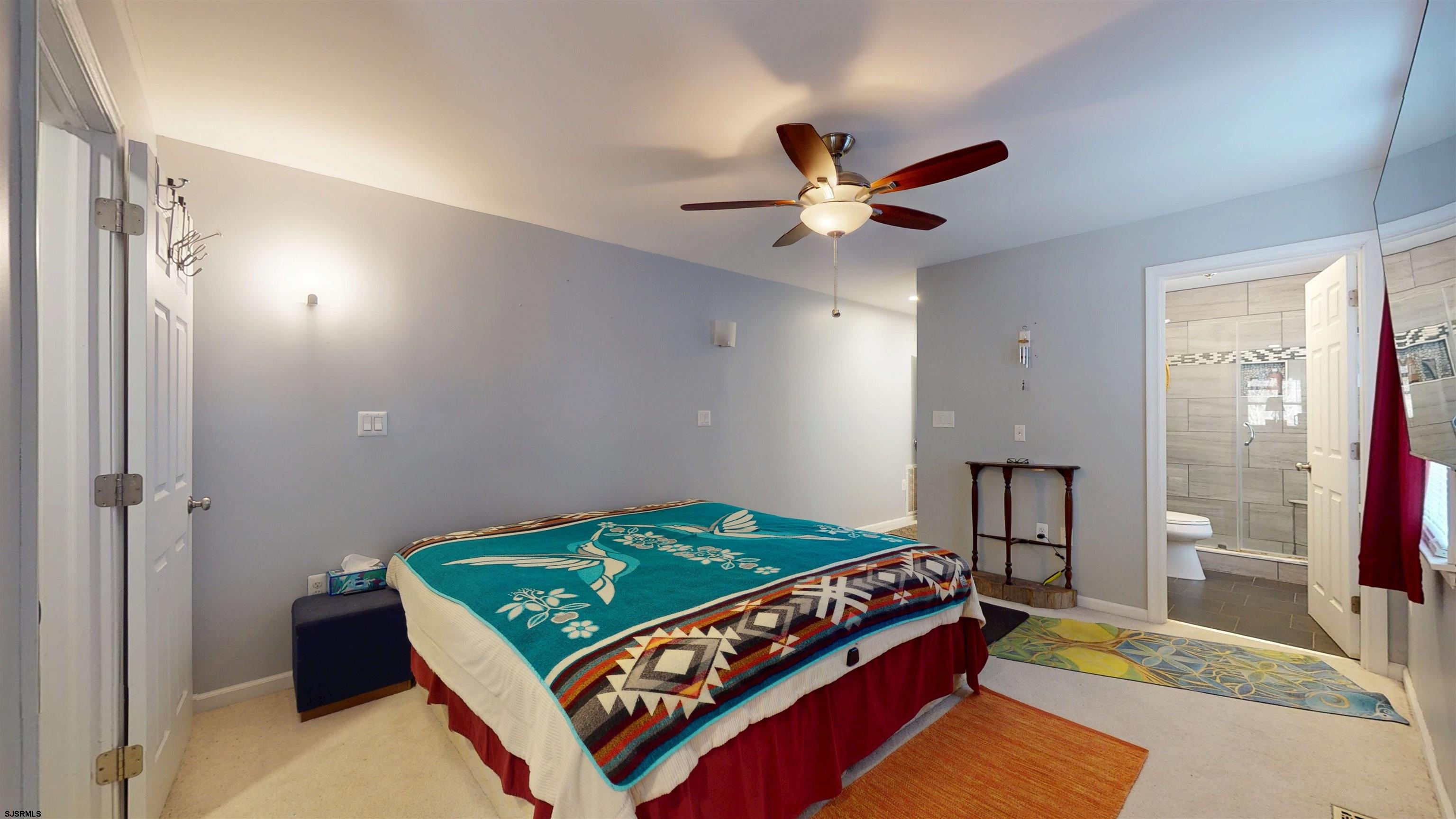 64 Clarks Landing Road Port Republic, NJ 08241 - Photo 23 of 63 a bedroom with a bed and a chandelier