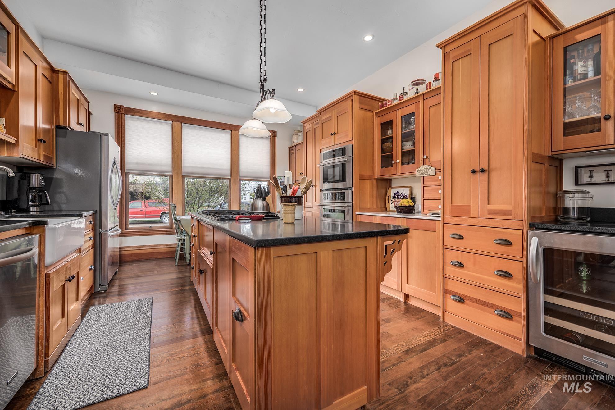 548 West 2nd Street Weiser, ID 83672 - Photo 11 of 50 Kitchen featuring glass insert cabinets, beverage cooler, hanging light fixtures, and stainless steel appliances