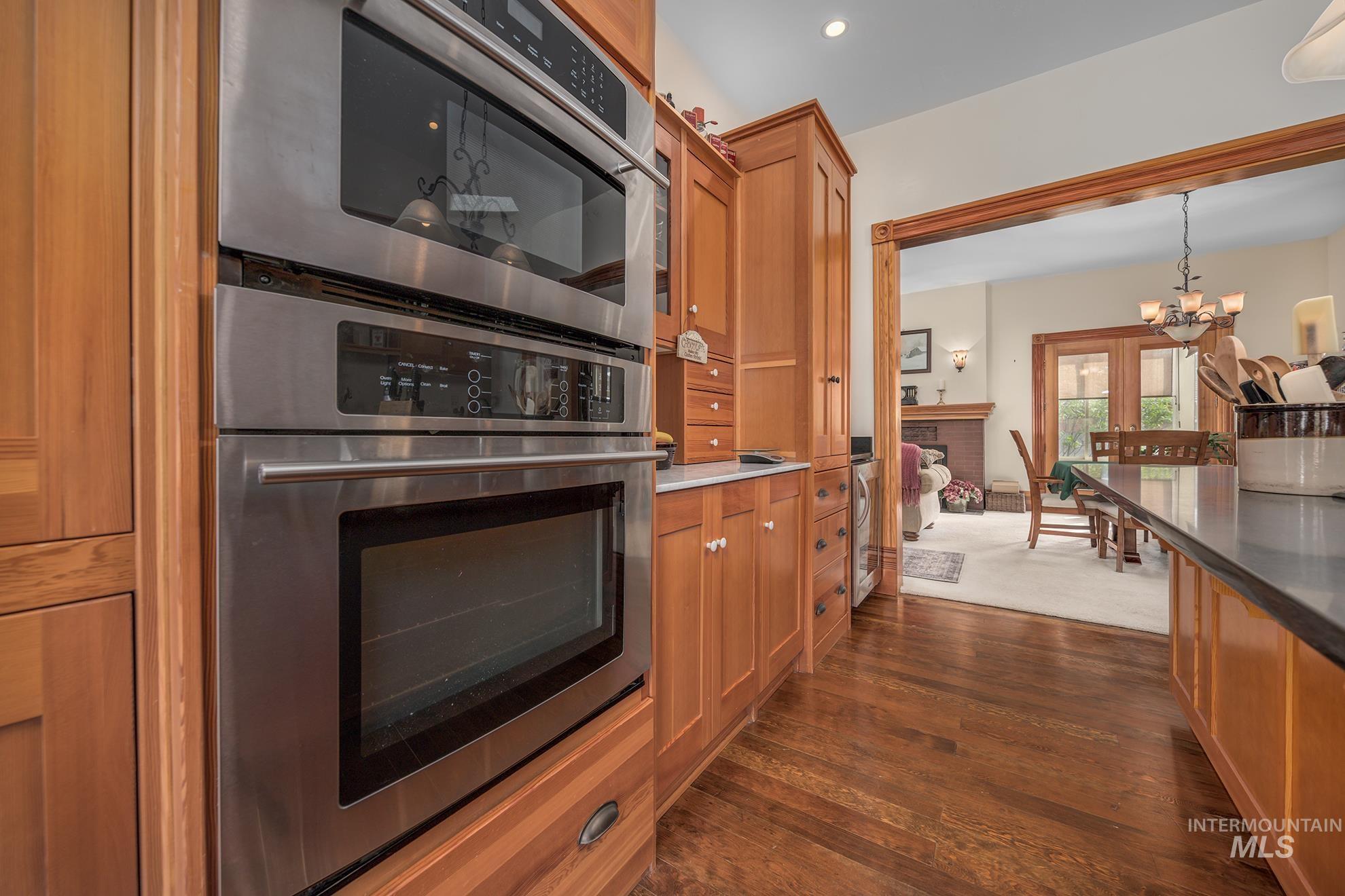 548 West 2nd Street Weiser, ID 83672 - Photo 14 of 50 Kitchen featuring a chandelier, dark wood-style floors, wood finish cabinetry, and dark stone countertops
