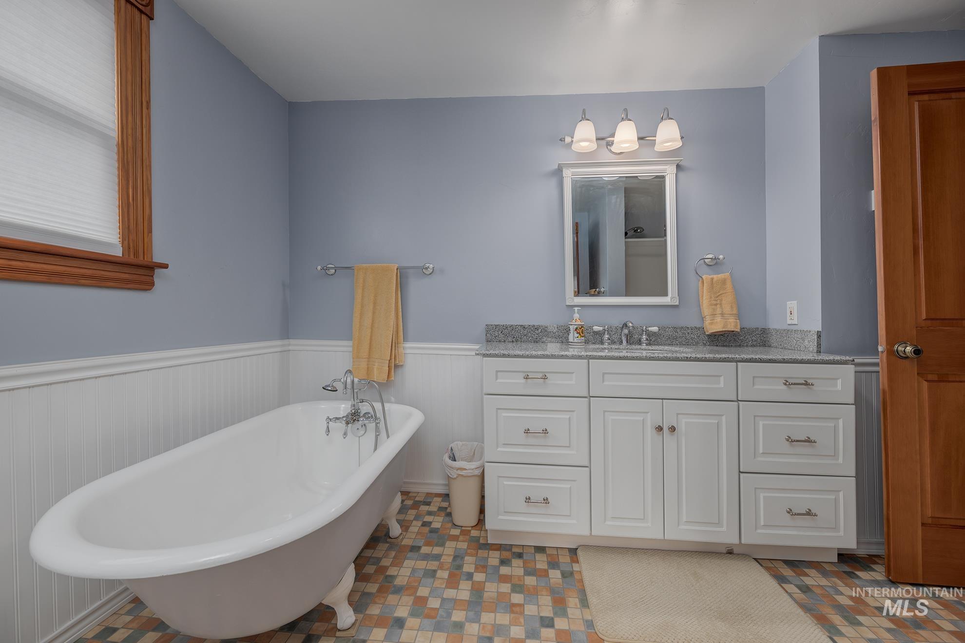 548 West 2nd Street Weiser, ID 83672 - Photo 27 of 50 Full bathroom with vanity, wainscoting, and a freestanding bath