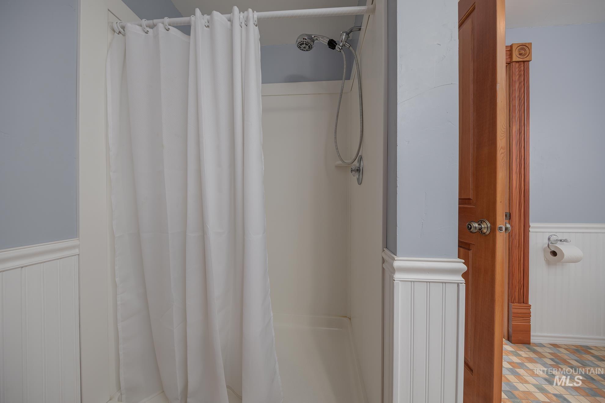 548 West 2nd Street Weiser, ID 83672 - Photo 29 of 50 Bathroom with a wainscoted wall, a shower stall, and wood walls