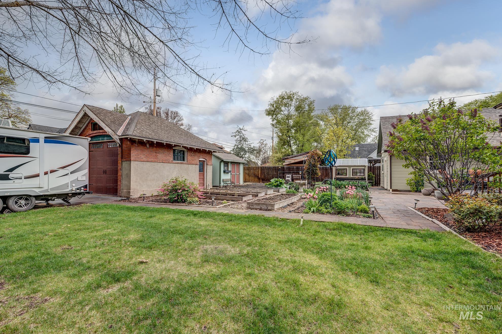 548 West 2nd Street Weiser, ID 83672 - Photo 46 of 50 Back of house featuring a vegetable garden, brick siding, and an outbuilding