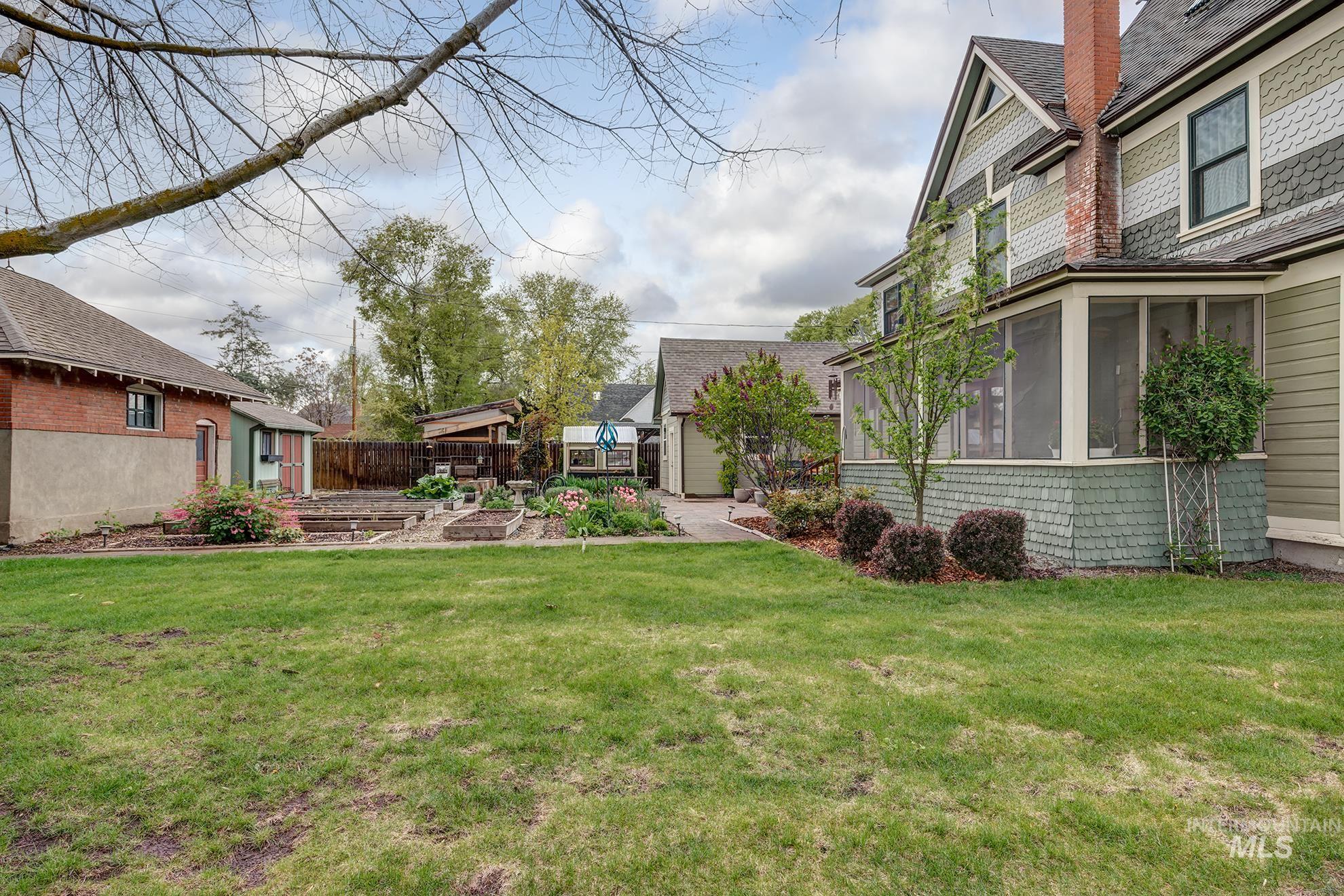 548 West 2nd Street Weiser, ID 83672 - Photo 47 of 50 View of yard with a vegetable garden, a patio area, a sunroom, and an outbuilding