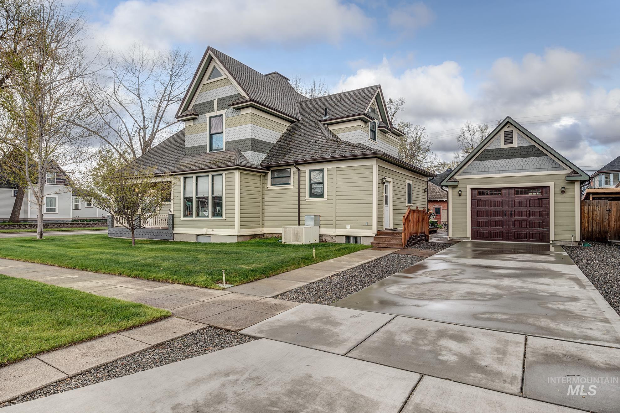 548 West 2nd Street Weiser, ID 83672 - Photo 48 of 50 Victorian-style house featuring a shingled roof, concrete driveway, an outdoor structure, and a detached garage