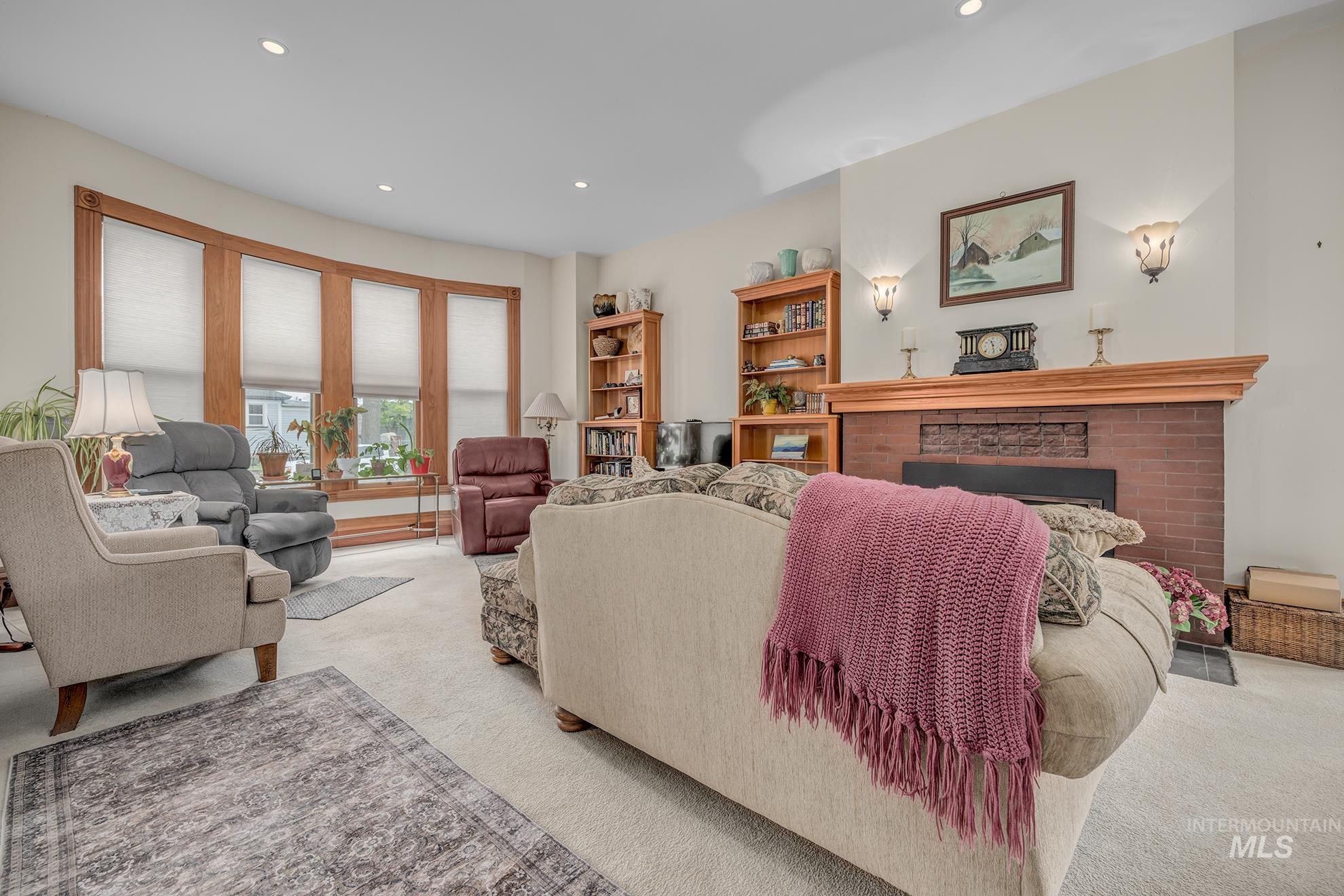 548 West 2nd Street Weiser, ID 83672 - Photo 5 of 50 Living area featuring light carpet, a brick fireplace, and recessed lighting