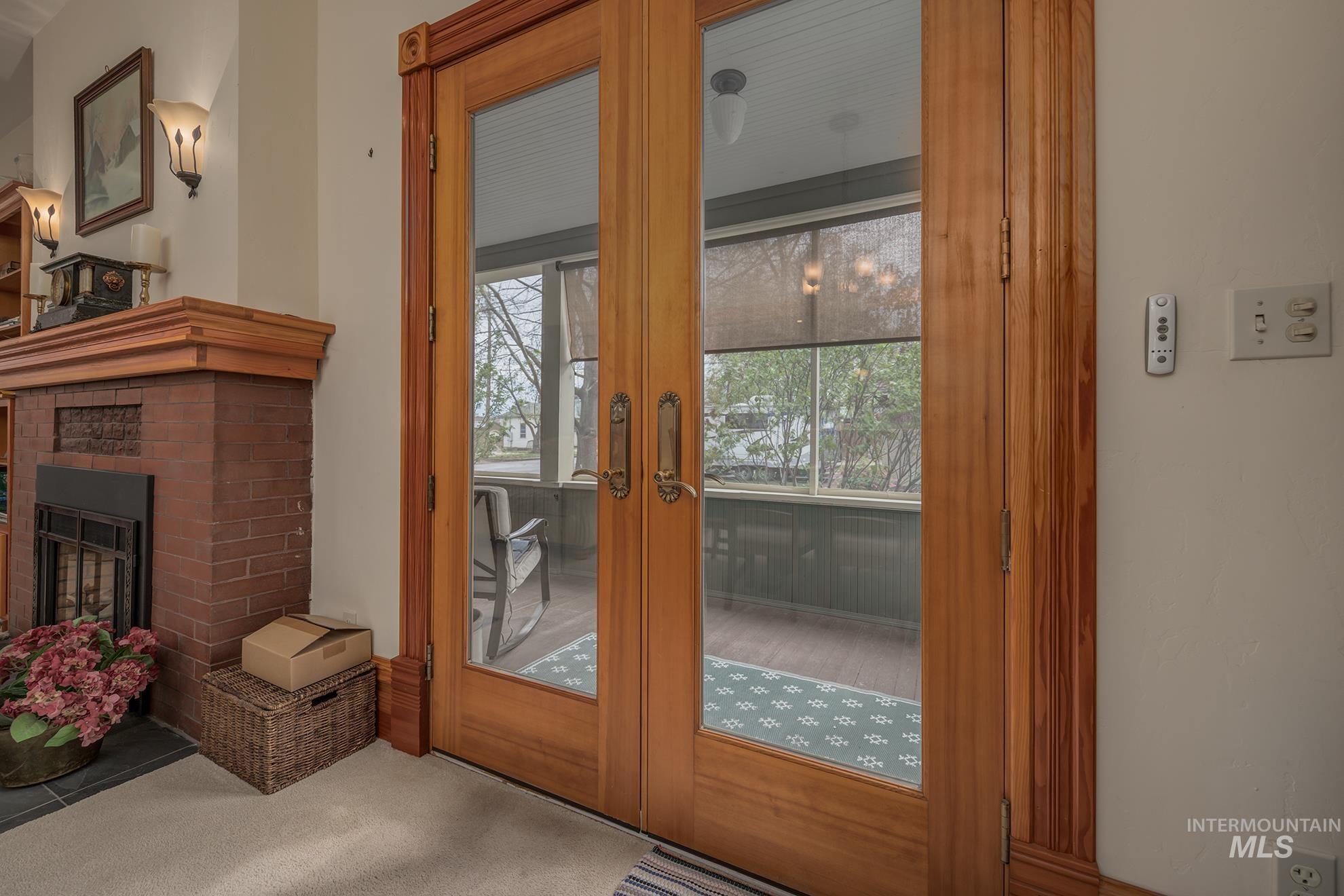 548 West 2nd Street Weiser, ID 83672 - Photo 8 of 50 Doorway to outside featuring a brick fireplace, carpet, and french doors