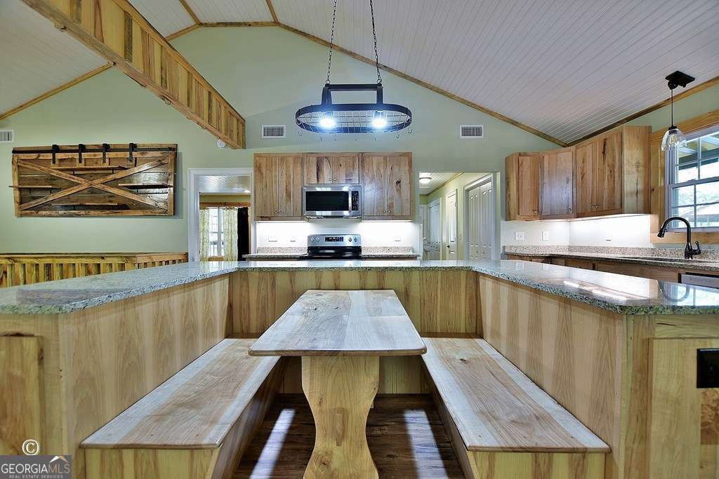 3175 Salem Road Pine Mountain, GA 31822 - Photo 24 of 41 a kitchen with stainless steel appliances granite countertop a table chairs in it and wooden floors