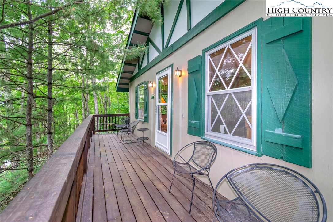 206 Oak Road Beech Mountain, NC 28604 - Photo 3 of 22 a view of a balcony with chairs and wooden floor