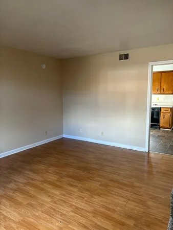 a view of empty room with wooden floor