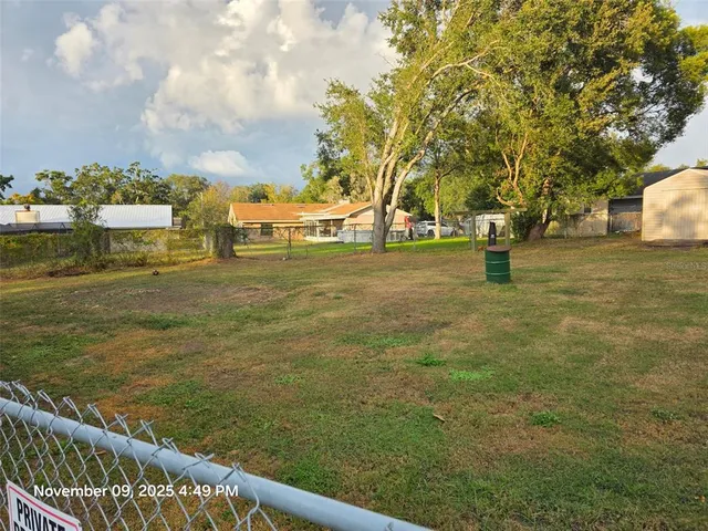 a yard with swimming pool and trees