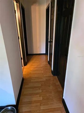 a view of a hallway with wooden floor and stairs