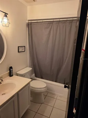 a bathroom with a sink a toilet a mirror and shower curtain