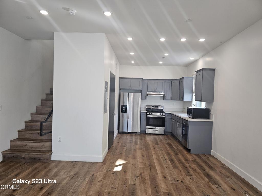 14550 Burbank Boulevard, Unit 103 Sherman Oaks, CA 91411 - Photo 7 of 27 a kitchen with kitchen island wooden floors appliances and cabinets