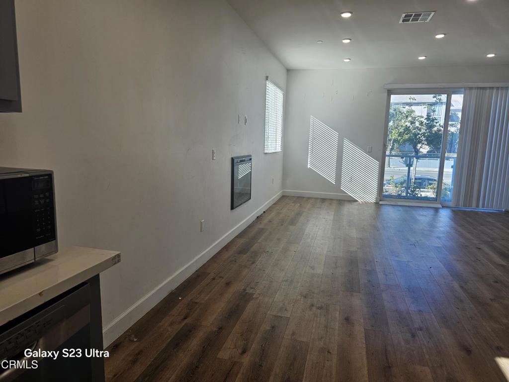 14550 Burbank Boulevard, Unit 103 Sherman Oaks, CA 91411 - Photo 8 of 27 wooden floor in an empty room with a window