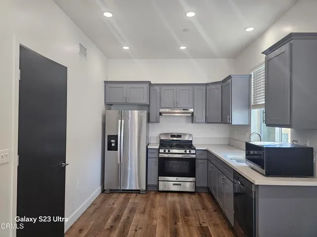 a kitchen with stainless steel appliances a sink stove and refrigerator