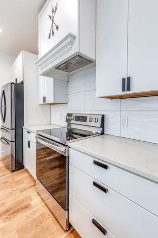 a kitchen with kitchen island a stove a refrigerator and cabinets