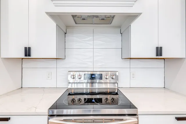 a stove top oven sitting inside of a kitchen