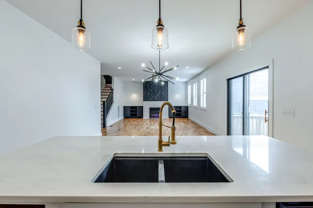 a view of kitchen with kitchen island a sink and a chandelier