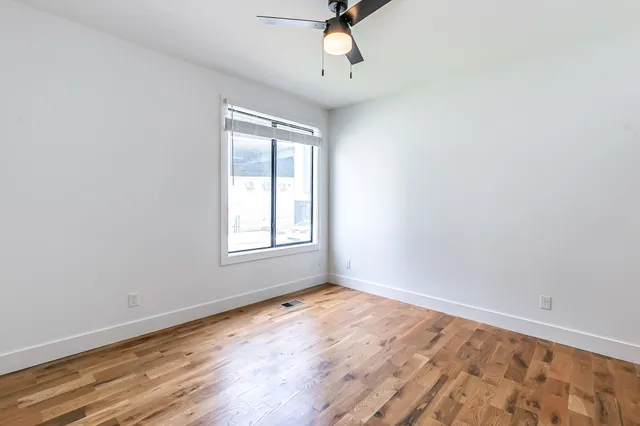 wooden floor in an empty room with a window