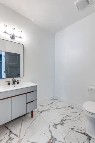 a bathroom with a sink toilet and mirror