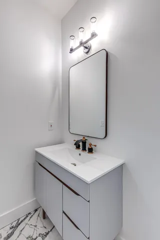a bathroom with a sink vanity and mirror