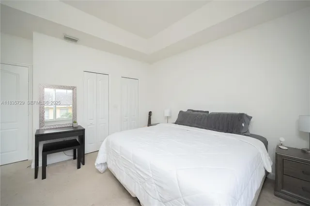 a bedroom with a bed table and a window