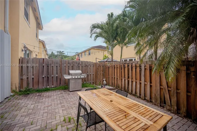 a view of a wooden dinning table and chairs in the patio