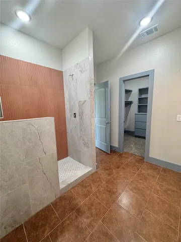 a view of a hallway view with wooden floor and a bathroom