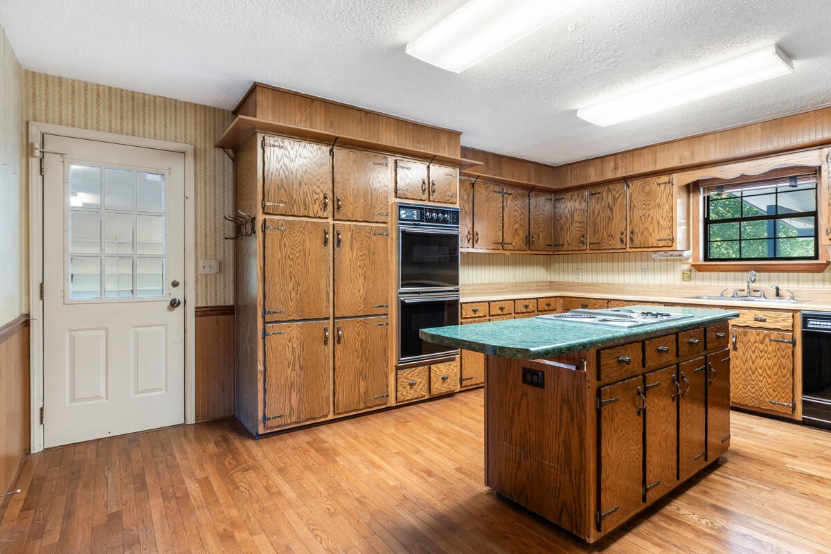 1471 New Hope Church Road Tunnel Hill, GA 30755 - Photo 18 of 45 a kitchen with stainless steel appliances granite countertop a stove a refrigerator and a sink with wooden cabinets