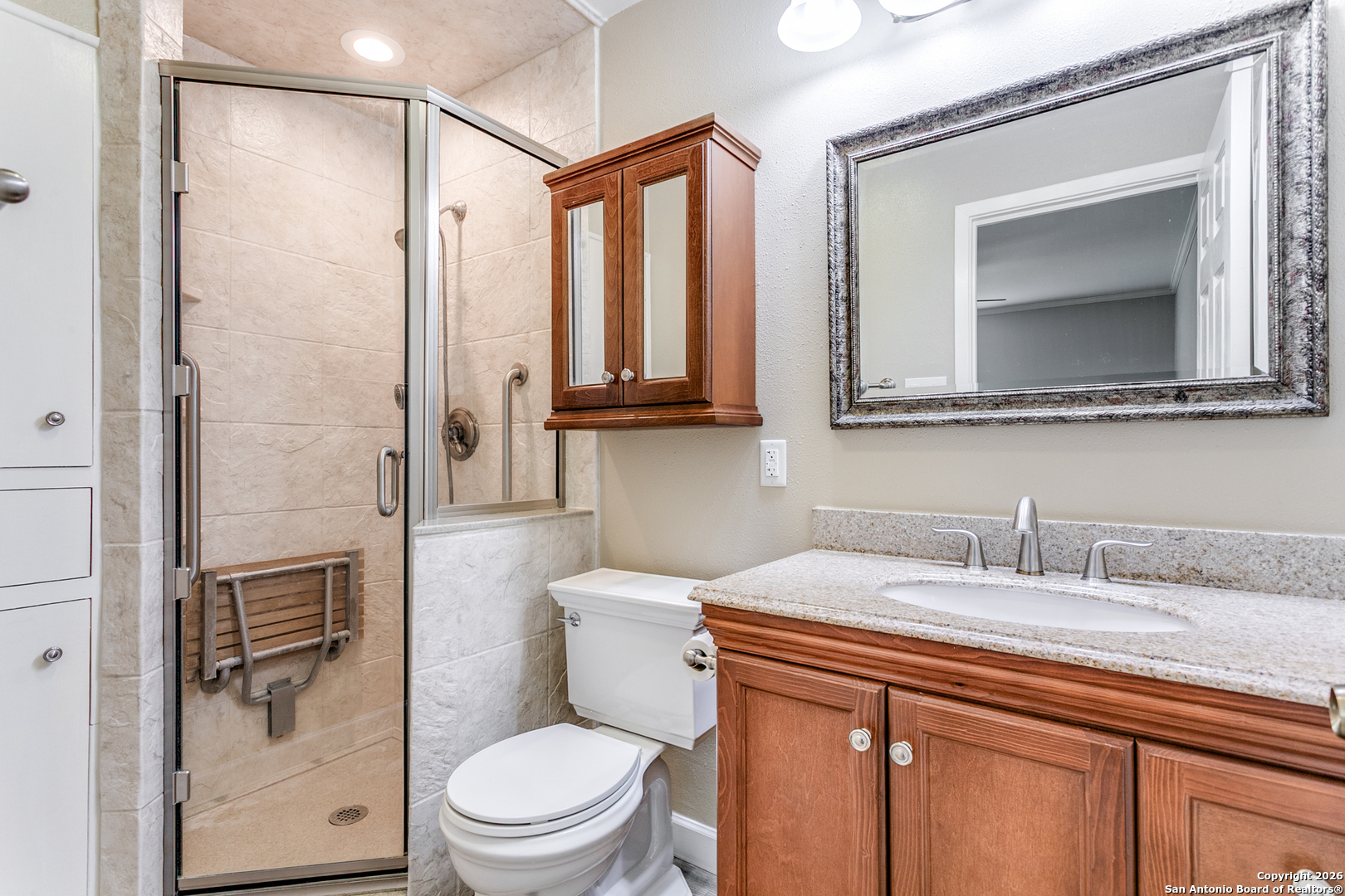 5302 Fair Ridge Drive San Antonio, TX 78228 - Photo 20 of 24 a bathroom with a granite countertop sink toilet a mirror a vanity and shower