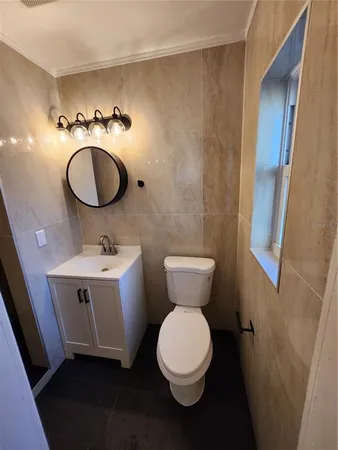 a bathroom with a toilet sink and mirror