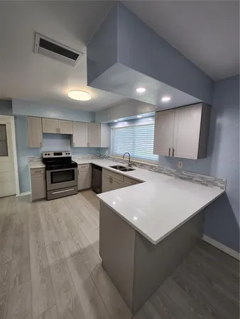 a kitchen with stainless steel appliances granite countertop a sink stove and a refrigerator