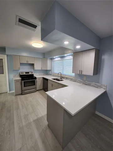 a kitchen with stainless steel appliances granite countertop a sink stove and a refrigerator