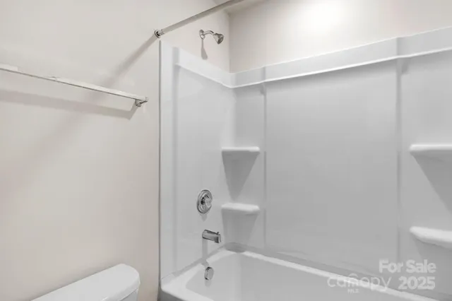a bathroom with a shower a toilet and a sink